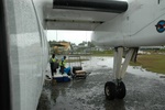 Solomon Airlines baggage handling at MUA/AGGM, airport fuel depot in the background.